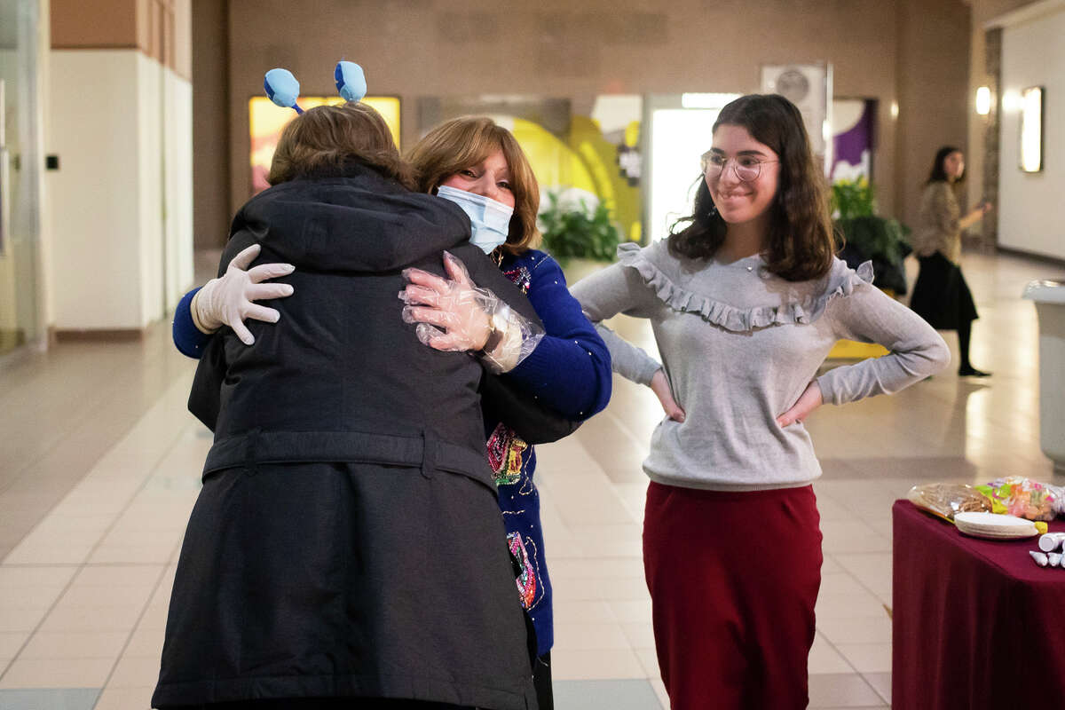 Shainie Weingarten, center, hugs a friend as Chabad of Eastern Michigan hosts a community-wide Hanukkah celebration, including the lighting of the menorah, Tuesday, Nov. 30, 2021 at the Midland Mall.