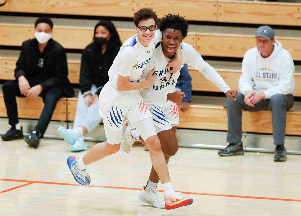 Grand Oaks forward Sammuel Nkassa (32) celebrates with guard Caleb Edwards (2) after hitting a shot at the buzzer to give the team a 61-59 win over Lake Creek during a non-district high school basketball game at Grand Oak Ridge School, Tuesday, Nov. 30, 2021, in Spring.