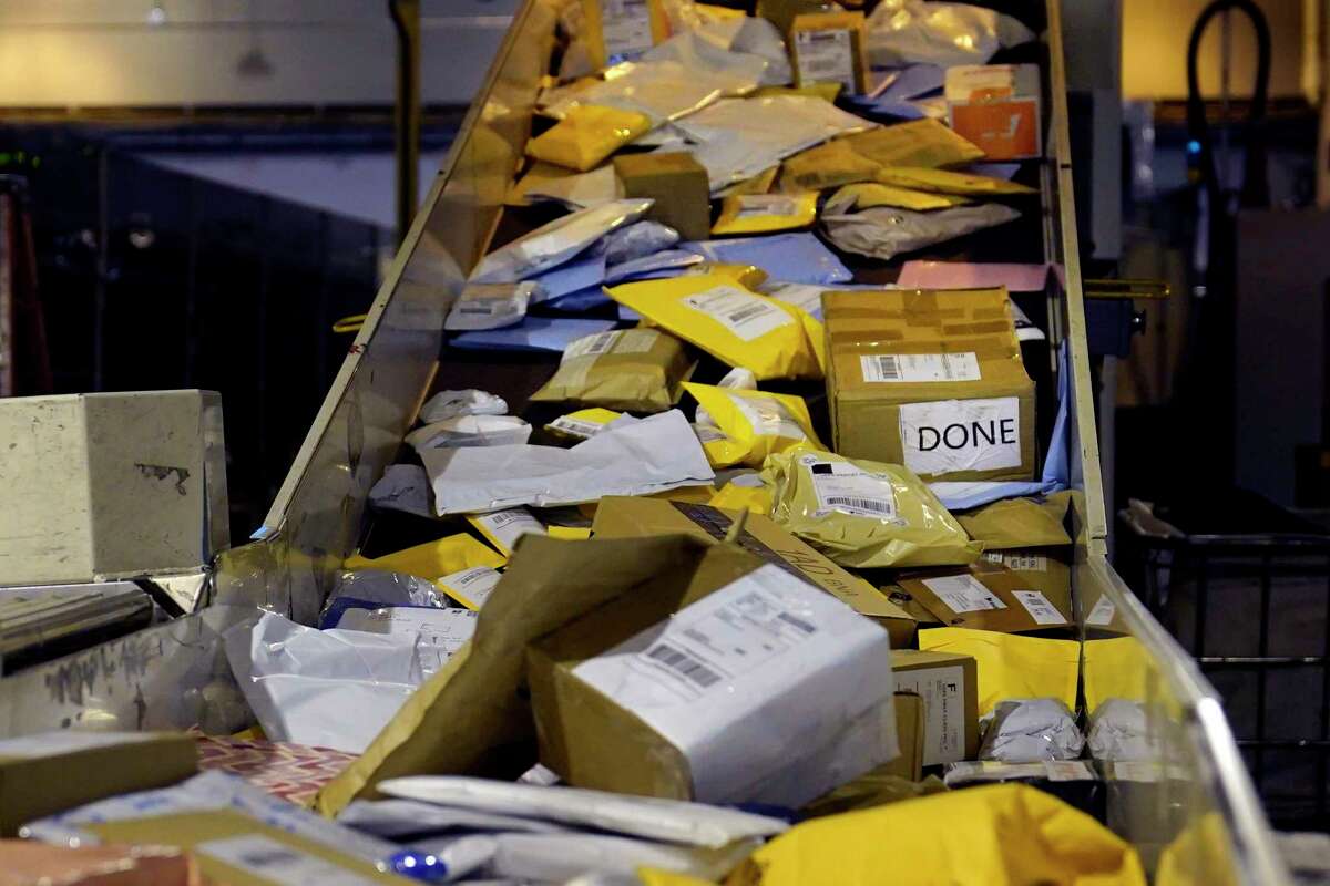 Parcels jam a conveyor belt at the United States Postal Service sorting and processing facility, Thursday, Nov. 18, 2021, in Boston.