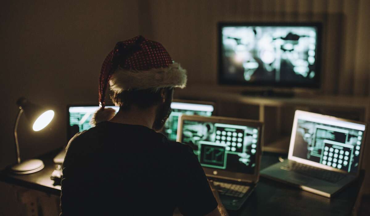 FILE — A  Computer hacker wears a santa hat while working on laptop late at night.