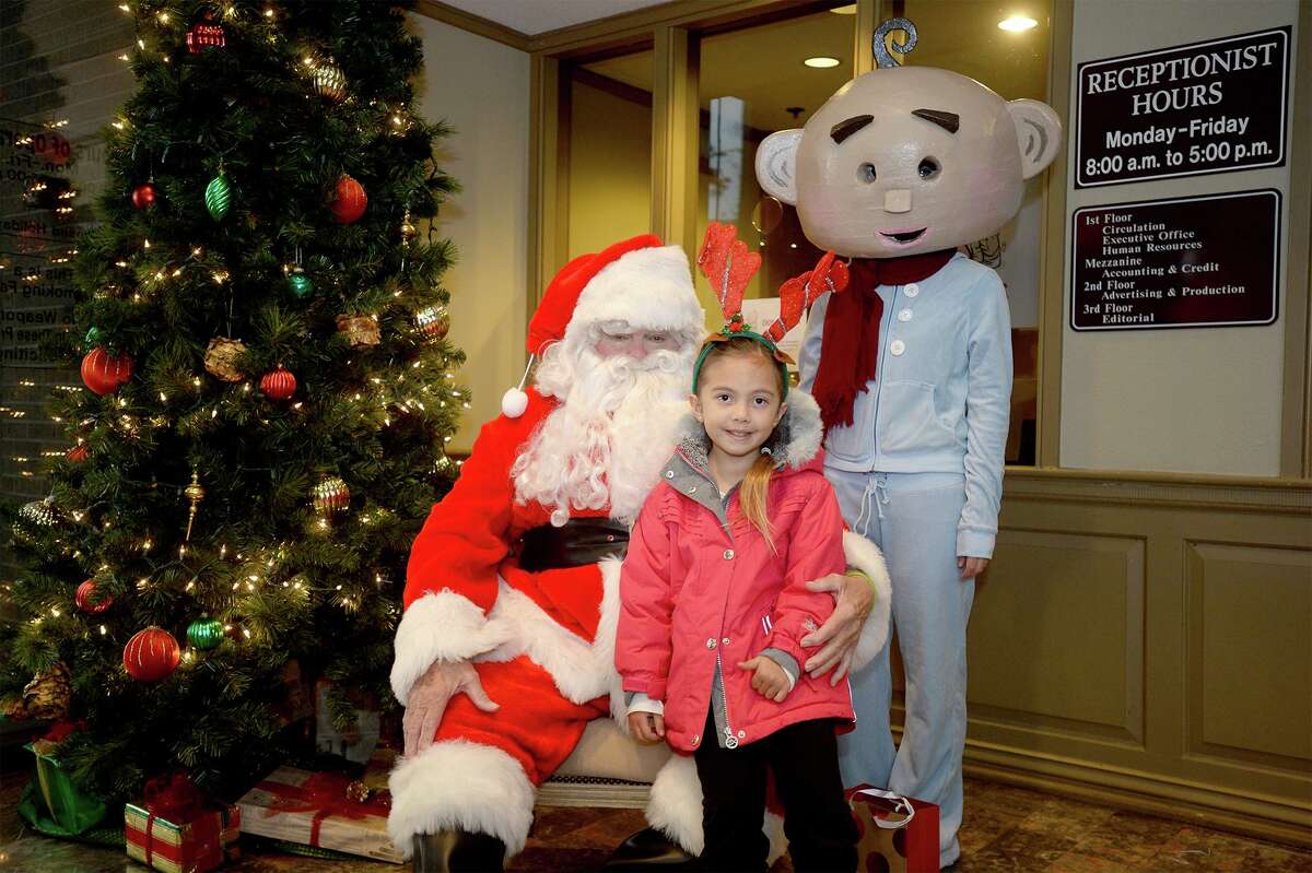 Lilyana Von Briscoe sits on Santa's lap with EJ at the Beaumont Enterprise Friday. Santa and EJ were on hand at the newspaper to help raise money for the Empty Stocking Fund. Photo taken Friday, December 08, 2017 Guiseppe Barranco/The Enterprise