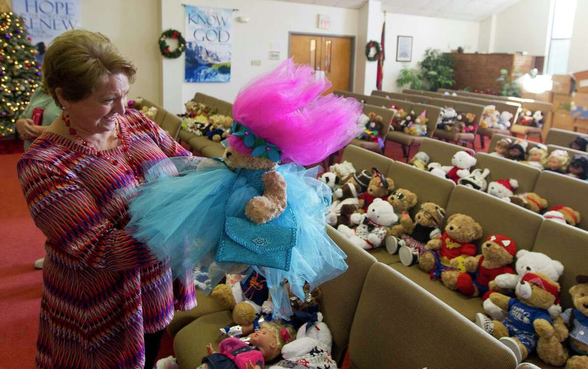 Cassy McLaren inspects a troll themed bear as she and other volunteers sort through 359 dolls and bears in preparation for the Salvation Army's annual Christmas Silver Tea, Friday, Dec. 1, 2017, in Conroe.