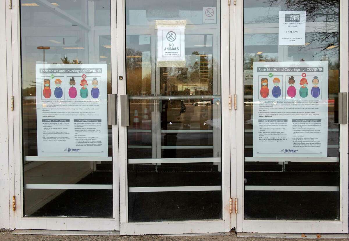 Signs are seen on the door to the entrance of the mass vaccination site in Aviation Mall on Wednesday, Dec. 1, 2021 in Queensbury, N.Y. Warren County will distribute KN-95 masks out of the mall this week. They are free.