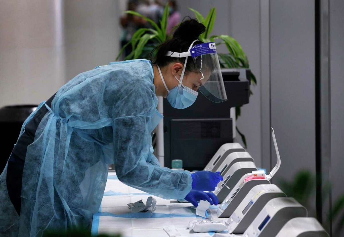A medical technician runs a rapid coronavirus test for a traveler at SFO in San Francisco in October 2020. Testing is being ramped up at SFO amid concern over the omicron variant.
