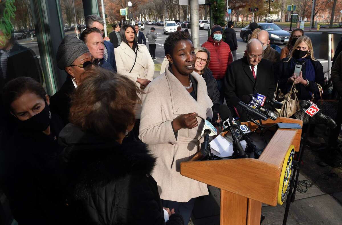 Andrea Barton Reeves (center), CEO of the Paid Family and Medical Leave Authority, answers questions about the family and medical leave program during a press conference in front of Claire's Corner Copia in New Haven on December 1, 2021, the first day the program began taking applications.