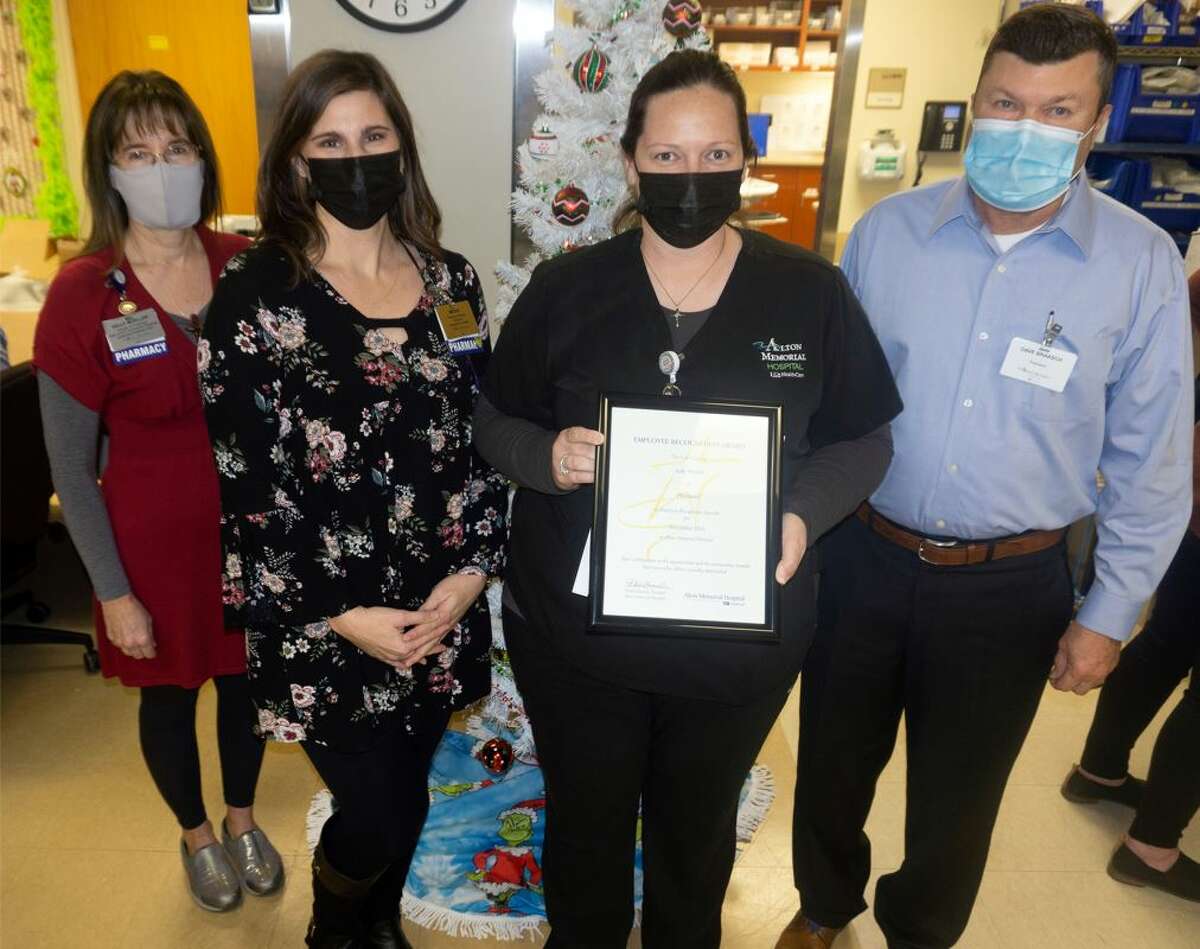 Jody Woods of the Inpatient Pharmacy, holding the plaque, is Alton Memorial Hospital’s December Employee of the Month. Also pictured, from left, are Kelly Mueller and Megan Flowers of the Pharmacy and AMH President Dave Braasch. Woods has been a pharmacy technician at AMH for 16 years.  