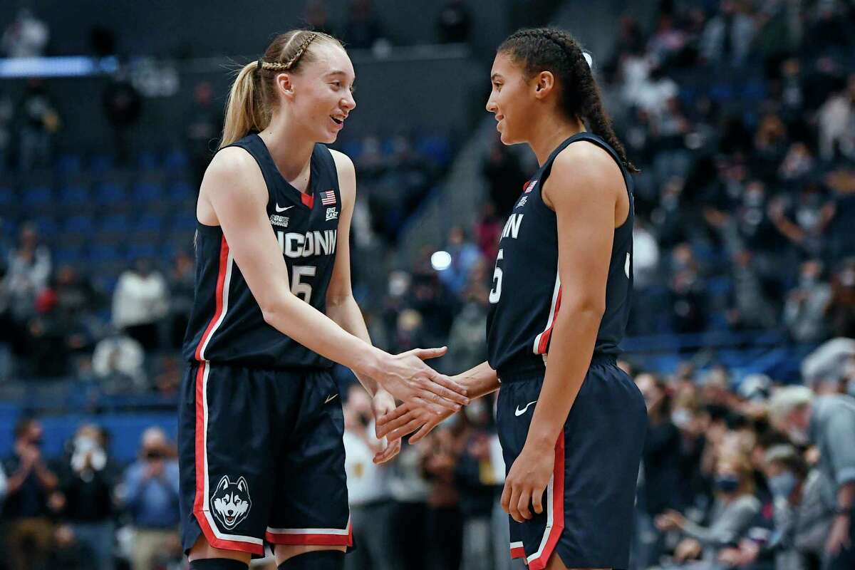 Connecticut's Paige Bueckers, left, shakes hands with teammate Azzi Fudd at the end of an NCAA college basketball game against Arkansas, Sunday, Nov. 14, 2021, in Hartford.