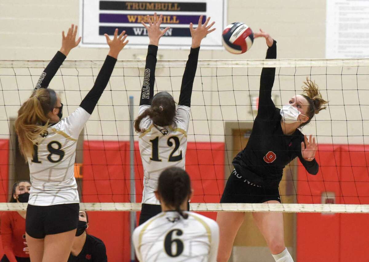 New Canaan's Lily Stevens (9) sends a shot over the net at Joel Barlow's Chloe Schwarz (18) and Meredith Asplund (12) during a volleyball match in New Canaan on Sept. 17, 2021.