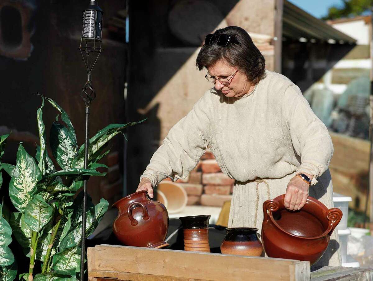 Kathy Blossom sets out pottery she made for her scene during a rehearsal for "Bethlehem City" at West Conroe Baptist Church, Wednesday, Dec. 1 2021, in Conroe. More than 100 actors reenactment scenes from Jesus' life in the drive-thru event. This year's experience opens Thursday. 