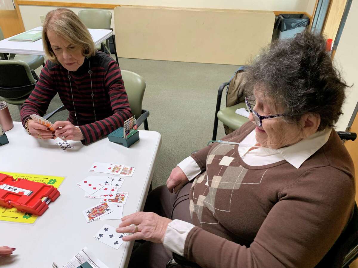 Lois Sheketoff, right, plays bridge with Barbara Malley-Falkin, left, at the West Hartford Senior Center. Sheketoff is a 100-year-old Hartford resident and this was her second time since the COVID-19 pandemic that she was able to leave her home to play bridge with her friends.