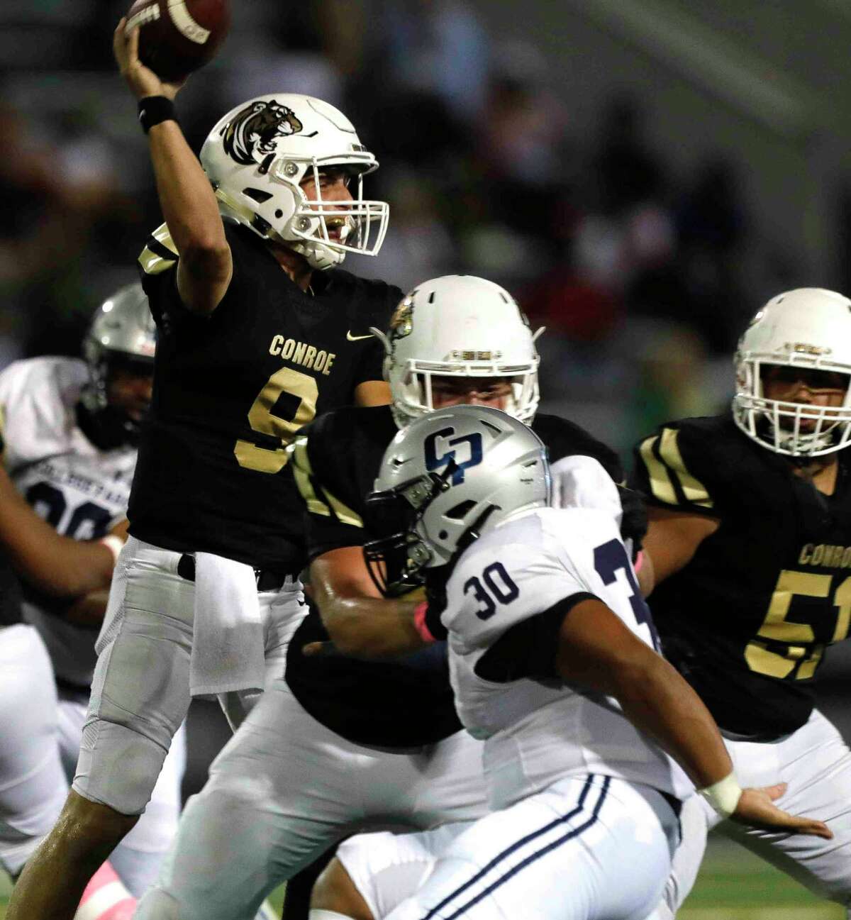 Conroe starting quarterback Clayton Garlock (9) throws under pressure during the second quarter of a high school football game at Buddy Moorhead Stadium, Friday, Oct. 22, 2021, in Conroe