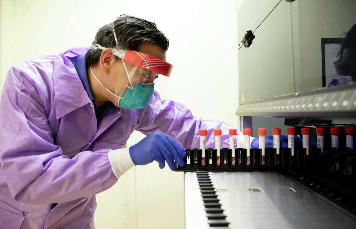 Dr. Charles Chiu, director of the UCSF-Abbott Viral Diagnostics and Discovery Center, inserts a tray of vials for the collection, transport, maintenance and long-term freeze storage of viruses into a Biomatrix sorter.