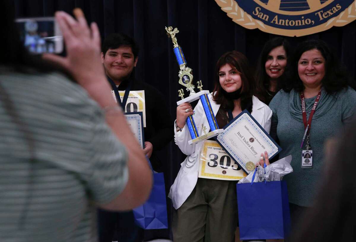Marshall High School sophomore Itzel Ricoy (center) poses for pictures after winning the high school division in the Northside ISD students Spanish spelling bee on Wednesday. Winners from the elementary, junior high and high school level will compete in the Region 20 Spanish spelling contest in February.