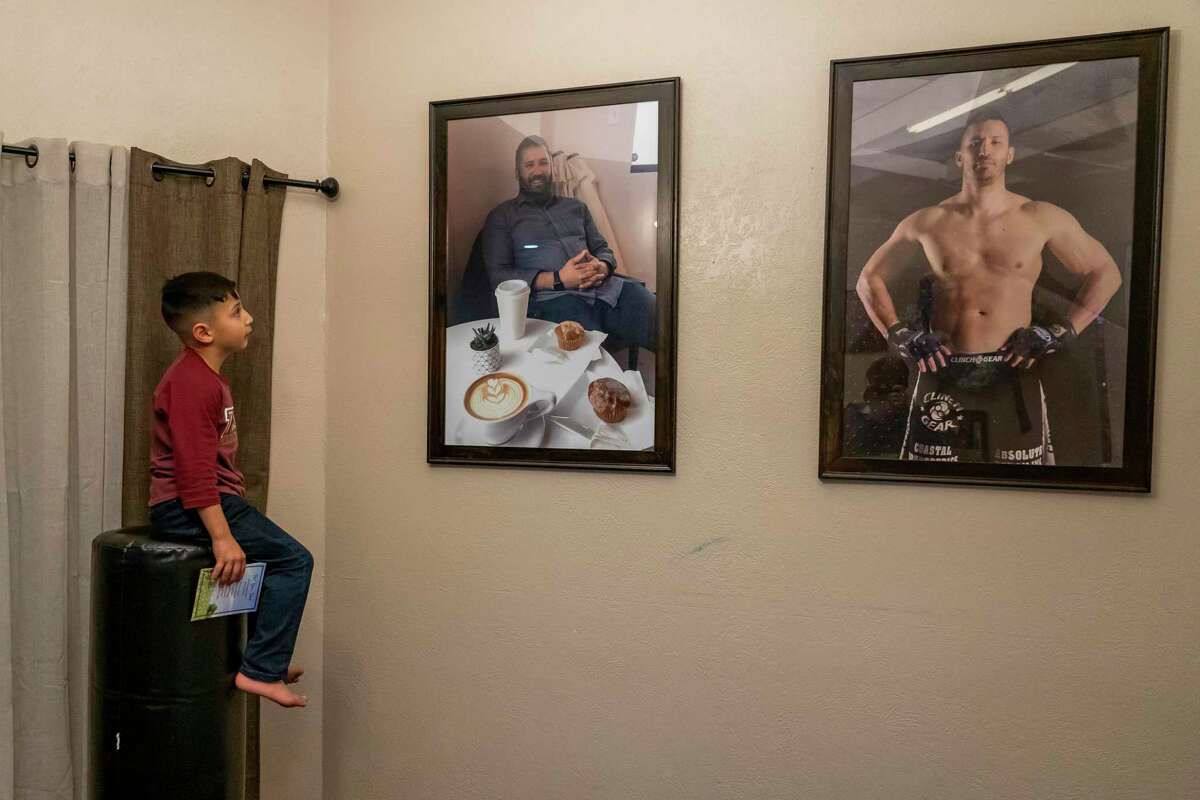Six-year-old Ayden Villegas looks at pictures of his father, Robert Villegas, who died in January after a three-week battle with COVID-19. Villegas’ widow, Valerie, a hospice nurse, is raising their children — five boys and a daughter — on her own.