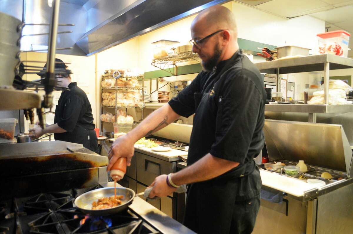 Evan Buchholz, executive chef at Cleveland-Heath, prepares chicken tacos on Thursday. Buchholz and his wife, Gina, are the new owners of the restaurant effective Dec. 6.