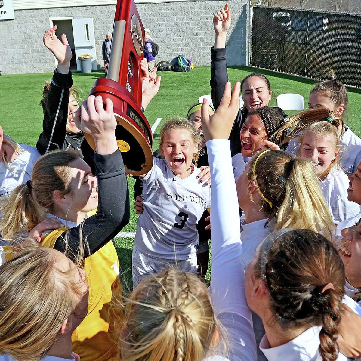 The Saint Rose women's soccer team holds the East Region trophy aloft after a 3-0 win over Mercy.