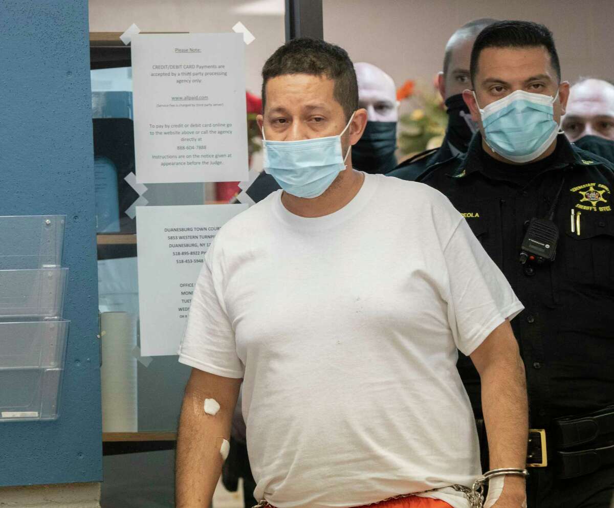 Nelson D. Patino, 47, is led into Duanesburg Town Court on Thursday, Dec. 2, 2021. Patino is charged with second-degree murder for allegedly killing his wife and older son the day before and leaving his younger son with stab wounds the night before.