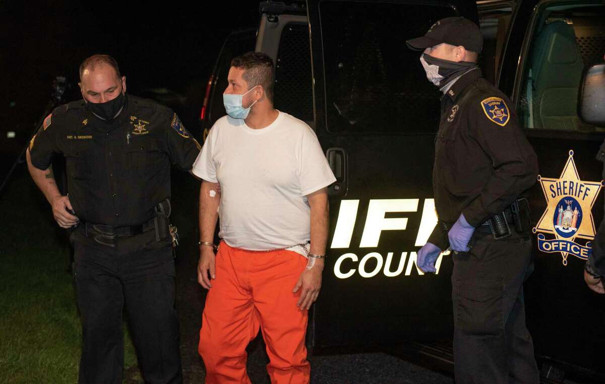Nelson D. Patino, 47, is lead into Duanesburg Town Court on Thursday, Dec. 2, 2021 in Duanesburg, N.Y. Patino is charged with second-degree murder in the stabbing deaths of a woman and child and attempted murder of a second child Wednesday night.