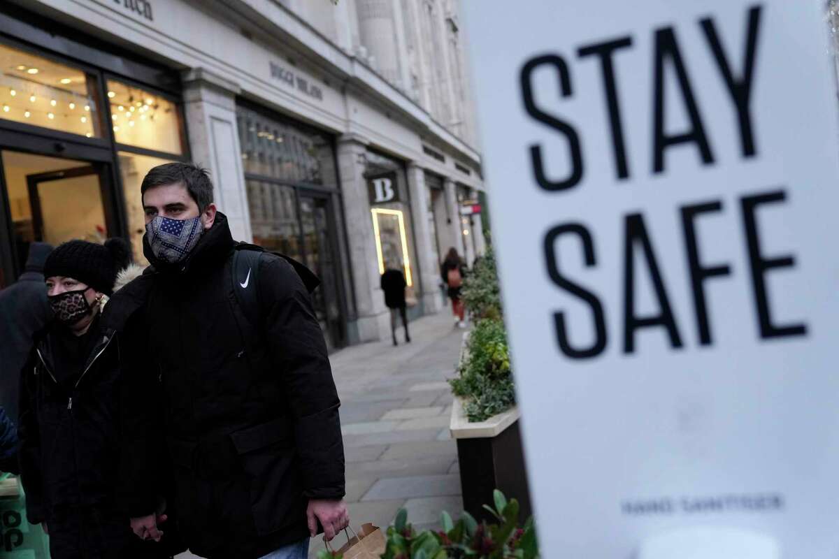 Pedestrians wearing face masks against the coronavirus walk along Regent Street in London, Tuesday, Nov. 30, 2021. A pandemic-weary world faces weeks of confusing uncertainty as countries restrict travel and take other steps to halt the newest potentially risky coronavirus mutant before anyone knows just how dangerous omicron really is.
