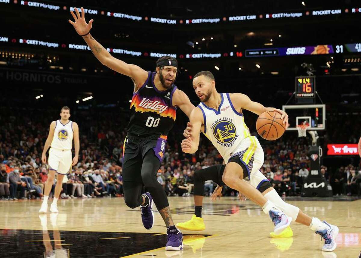 The Warriors’ Stephen Curry drives the ball against former teammate JaVale McGee in Tuesday night’s game. The Suns held Curry to 4-for-21 shooting, the worst showing in a game in which he’s attempted at least 20 shots in his NBA career.