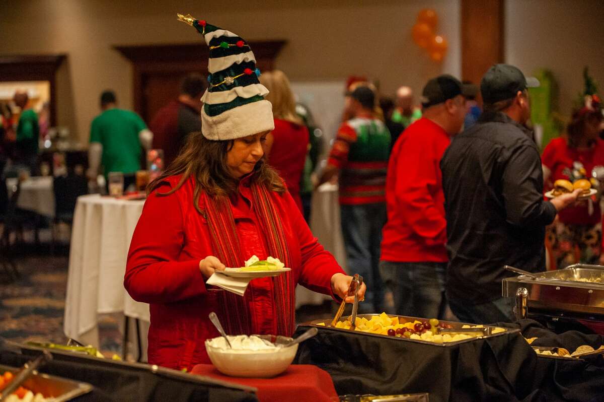 Frankenmuth resident Amy Saha gets a plate of food at Community Wishes' Holiday Gala on Dec. 2, 2021 at the Great Hall.