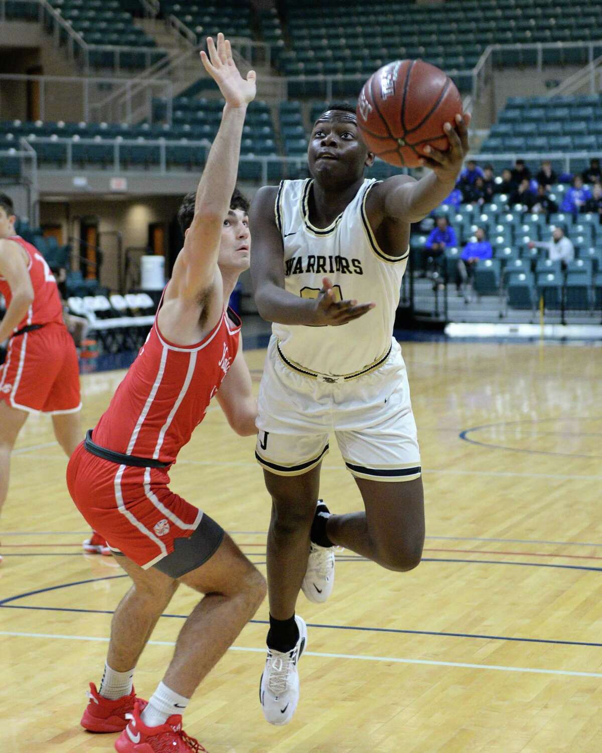 Jude Oluokun (21) of Jordan drives past Aydan Perdue (14) of Katy in the first half of a pool game between the Katy Tigers and the Jordan Warriors during the Katy ISD Basketball Classic on Thursday, December 2, 2021 at the Leonard Merrill Center, Katy, TX.