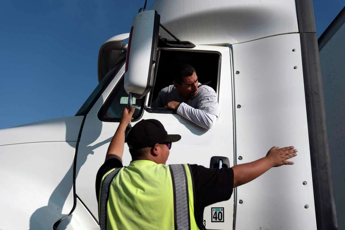 Senior instructor Markus Juarez, bottom, talks to student driver Jaime Rojas at California Truck Driving Academy in Inglewood, Calif., Wednesday, Nov. 17, 2021. Amid a shortage of commercial truck drivers across the U.S., a Southern California truck driving school sees an unprecedented increase in enrollment numbers. The increase is big enough that the school is starting an evening class to meet the demand, according to Tina Singh, owner and academy director of California Truck Driving Academy. "I think that's only going to continue because there's a lot of job opportunities. We have over 100 active jobs on our job board right now," said Singh. The companies that normally would not hire drivers straight out of school are "100 percent" willing to hire them due to shortage issues, the director added. (AP Photo/Jae C. Hong)