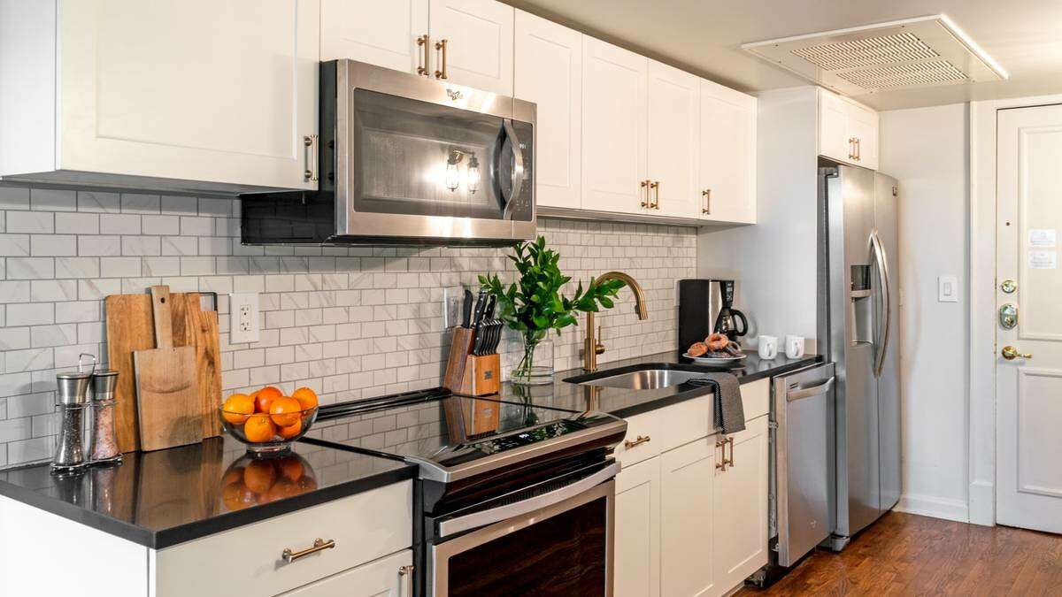 The kitchen, albeit a small space, is still beautiful with its white tile back splash and moderns appliances.