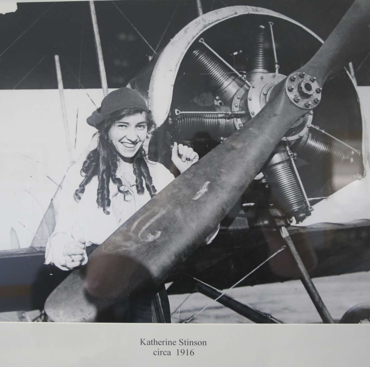 A copy of a 1916 photo hanging in the Stinson Airport terminal shows Katherine Stinson standing next to a plane at what was then Stinson Field. She and her family were the first women to own a flying school, according to Guinness.
