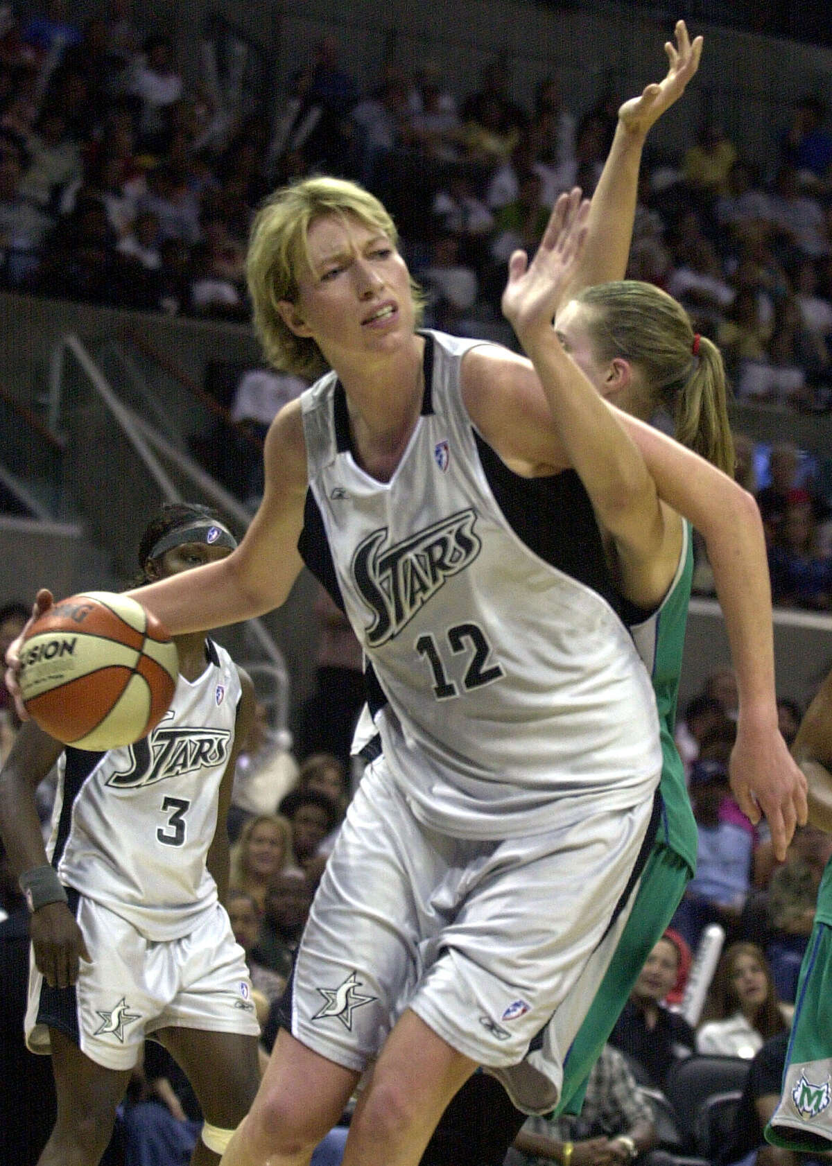 Former San Antonio Silver Stars player Margo Dydek (12) ducks under the arm of Michele Van Gorp in 2003. She holds the Guinness World Record for the most career blocks in the WNBA.