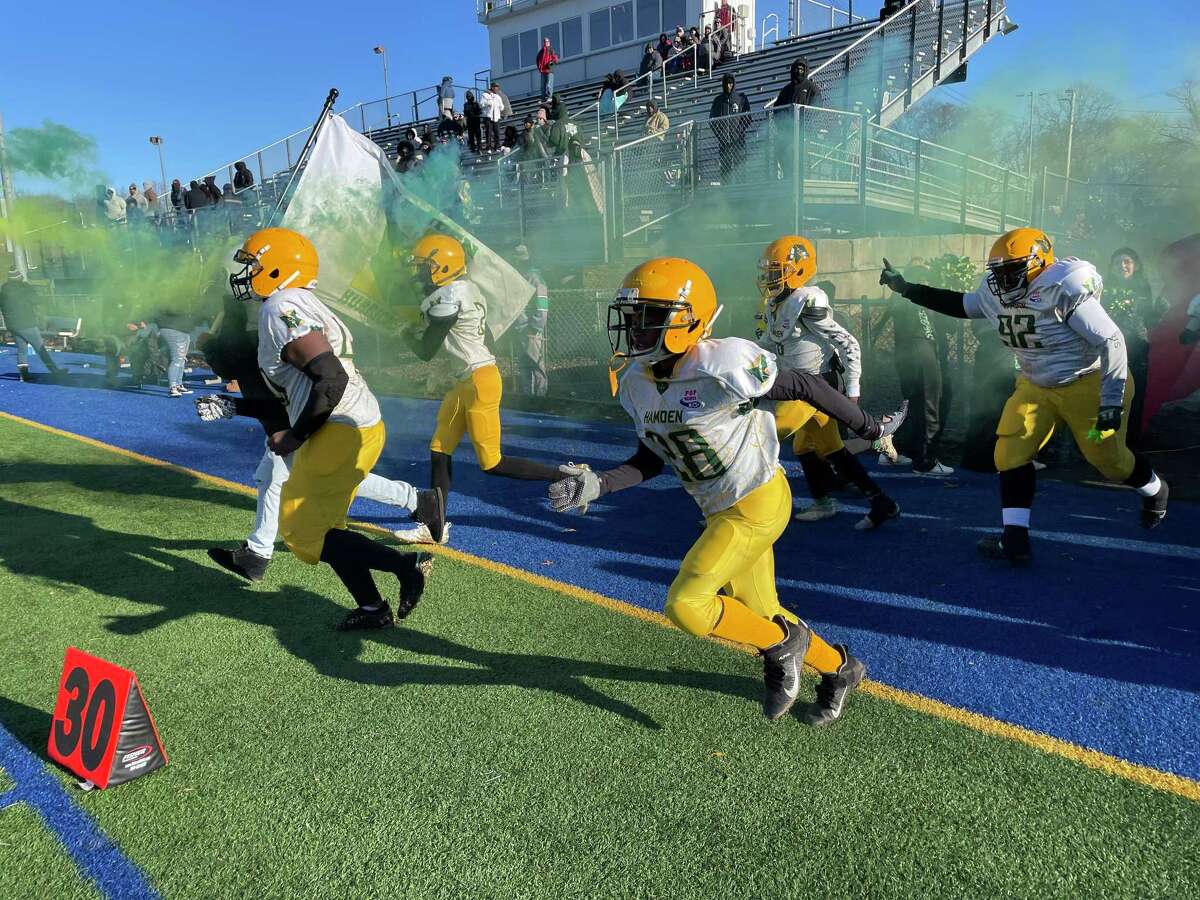 The Hamden Hurricanes 12U football team runs onto the field for the New England Regional Championship game at Veterans Memorial Field in West Haven, Conn. Nov. 27, 2021