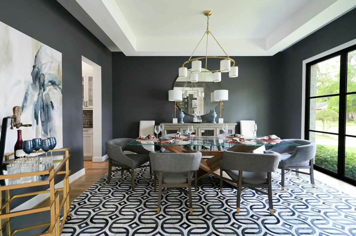 A cowhide rug stitched into a geometric print sits beneath a custom table designed by interior designer Cassandra Brand. The walls are painted Sherwin-Williams “Peppercorn.”