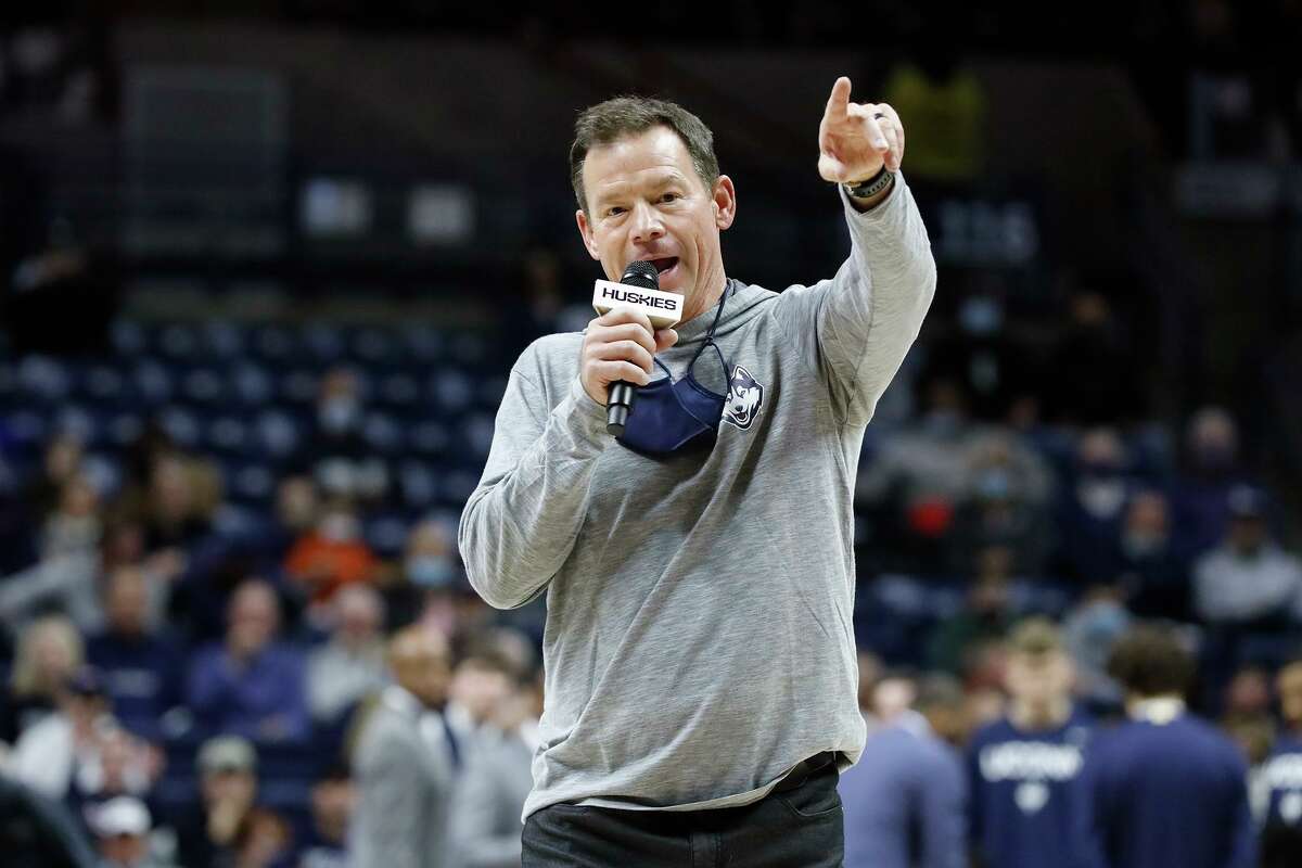 Connecticut football coach Jim Mora addresses basketball fans during a timeout in the game between Connecticut and Long Island at the University of Connecticut Wednesday Nov. 17, 2021, in Storrs, Conn.(AP Photo/Paul Connors)