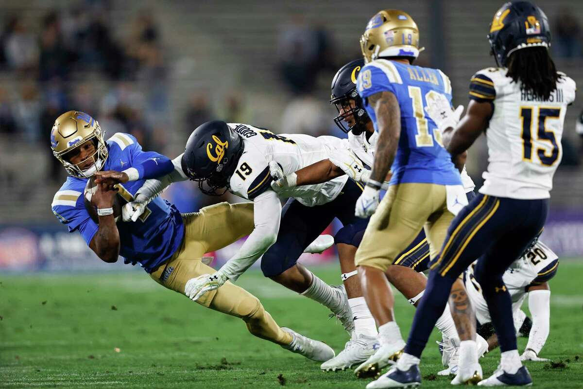 UCLA quarterback Dorian Thompson-Robinson, left, is tackled by Cal's Cameron Goode (19) during the first half at Rose Bowl on Saturday, Nov. 27, 2021, in Pasadena, California. The Bruins routed Cal, 42-14. (Michael Owens/Getty Images/TNS)