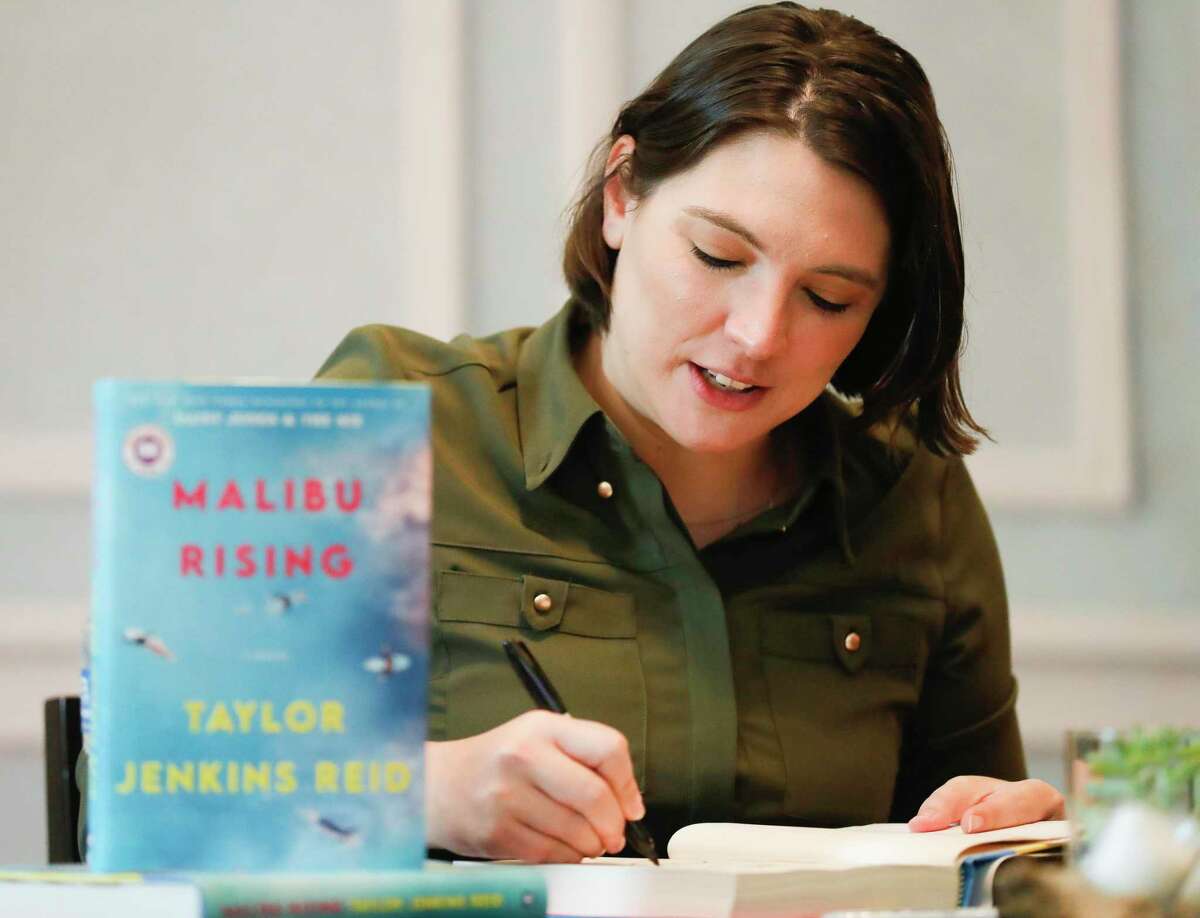 Author Taylor Jenkins Reid signs copies of her book ‘Malibu Rising’ during the John Cooper School Signature Author Series, Friday, Dec. 3, 2021, in The Woodlands.