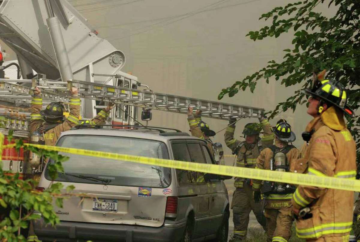 Firefighters work at the scene of a fire at 3237 Seventh Ave. in Troy Wednesday morning. (Michael P. Farrell / Times Union)