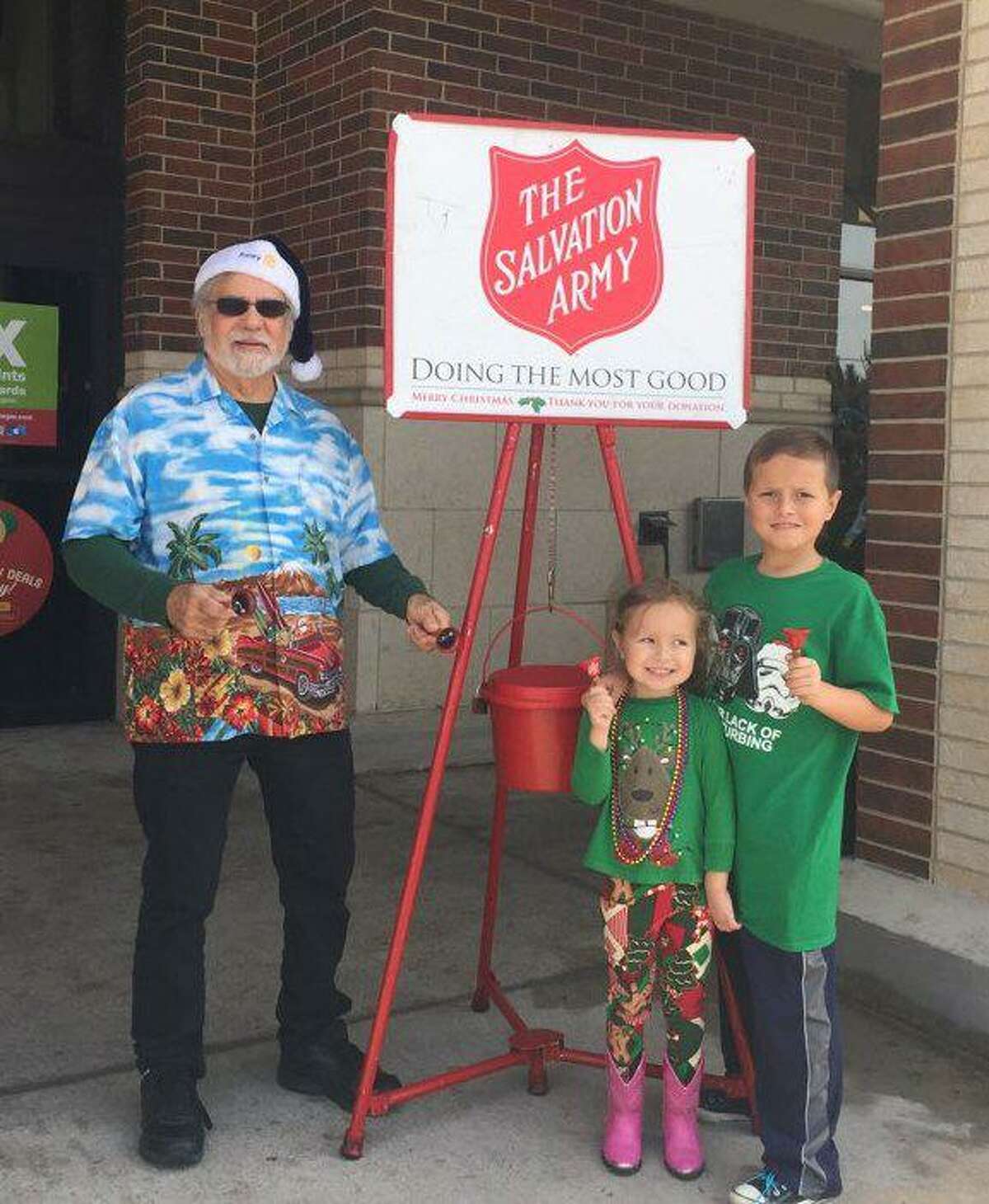 Pictured are Michael McBride with Annie and Henry Hernandez ringing the bell for the Salvation Army at a Kroger's as a part of the Rotary Club of Conroe. Rotary bell ringers will be out again on Saturday in front of the Kroger's on the South Loop.