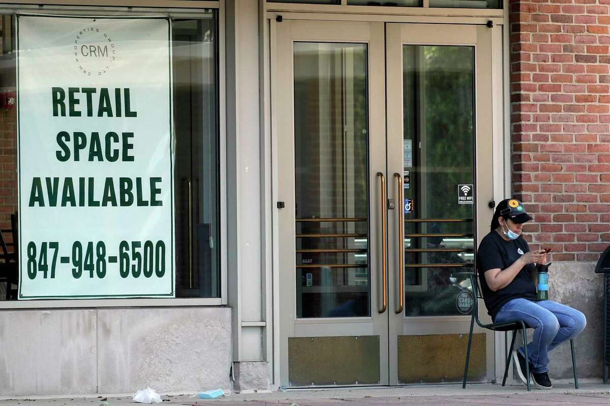 A woman looks at her phone outside of a rental sign displayed at a store in Deerfield, Ill., Thursday, June 11, 2020. The Labor Department said Thursday that about 1.5 million people applied for U.S. unemployment benefits last week, another sign that many Americans are still losing their jobs even as the economy begins to gradually reopen. (AP Photo/Nam Y. Huh)