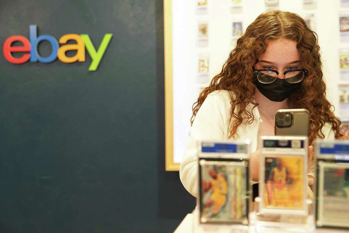 Vanessa Stevens takes a photo of Kobe Bryant trading cards at the “hard to find” shop by eBay in Houston on Friday, Dec. 3, 2021. The pop-up shop, which features rare trading cards and comics, has different items in different cities across the U.S., will only be open until Dec. 4 in Houston.