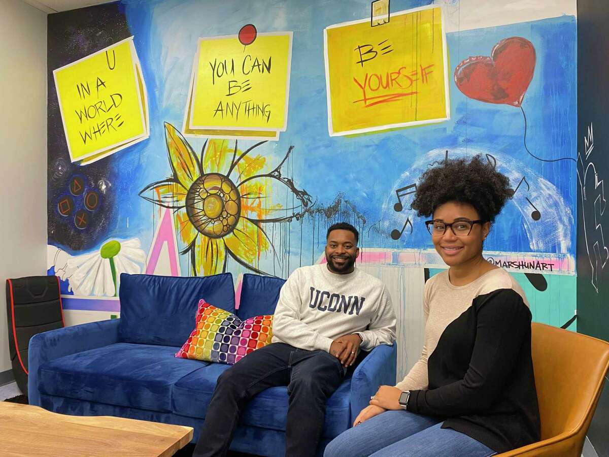 Brittany Roberts, right, a caseworker with the state Department of Children and Families, and Rodney Moore Jr., casework supervisor, in one of the refurbished visitation rooms at DCF's offices at 1 Long Wharf in New Haven. The room was painted by Marsh (MarshunArt).