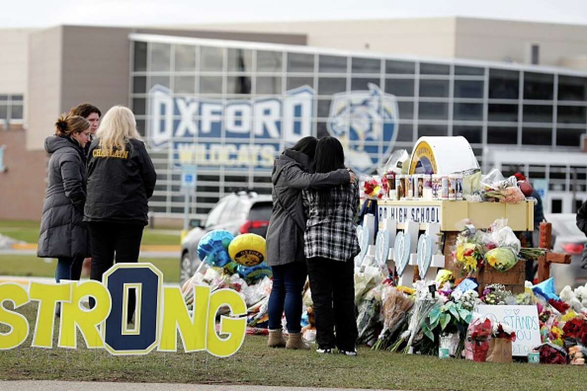 People gather at a memorial for the dead and wounded outside of Oxford High School in Oxford, Michigan.