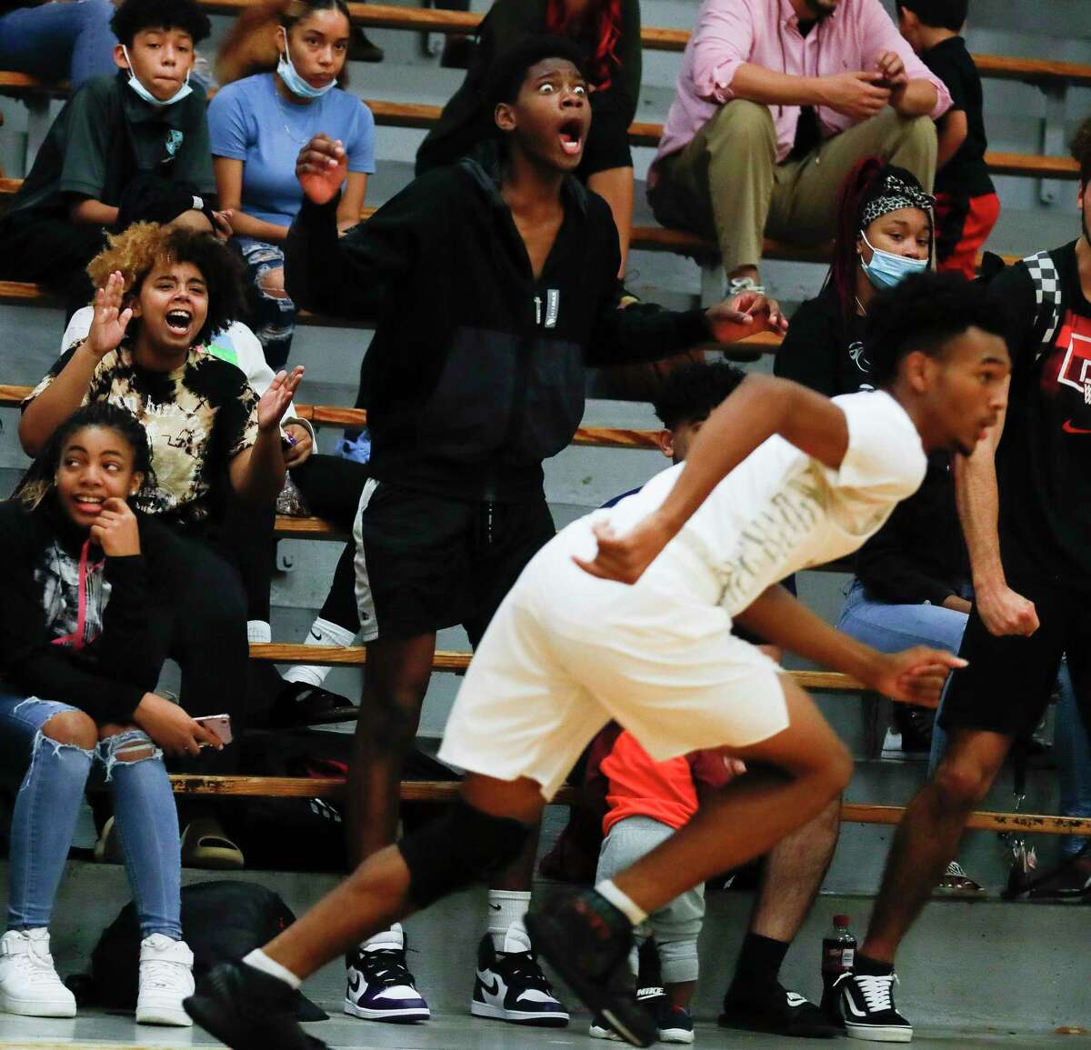 Conroe fans react after a three-pointer by point guard Niglel Leday during the first quarter of a non-district high school basketball game at Conroe High School, Friday, Dec. 3, 2021, in Conroe.