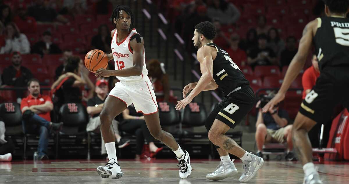 Houston guard Tramon Mark (12) controls the ball against Bryant forward Hall Elisias (34) during the first half of an NCAA college basketball game Friday, Dec. 3, 2021, in Houston. (AP Photo/Justin Rex)