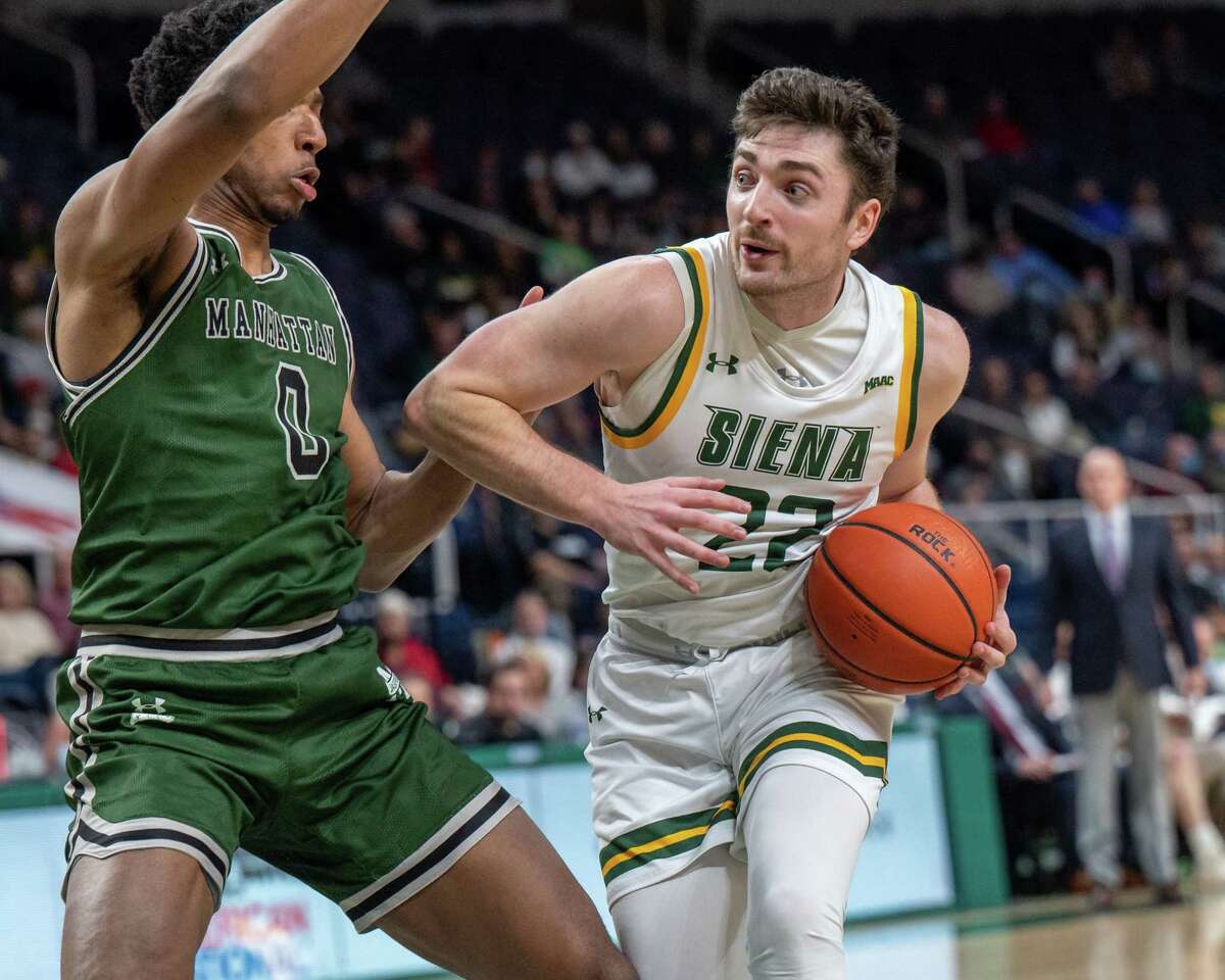 Siena College fifth year student Andrew Platek drives to the hoop in front of Manhattan College senior Warren William during the Metro Atlantic Athletic Conference opener at the Times Union Center in Albany, New York on Friday, Dec. 3, 2021 (Jim Franco/Special to the Times Union)