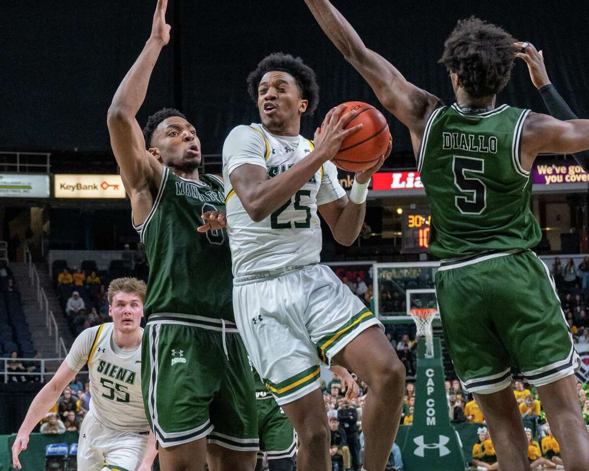 Siena College sophomore Aidan Carpenter drives to the basket while defended by Manhattan College senior Warren Williams (No. 0) and senior Samba Diallo during the Metro Atlantic Athletic Conference opener at the Times Union Center in Albany, New York on Friday, Dec. 3, 2021 (Jim Franco/Special to the Times Union)