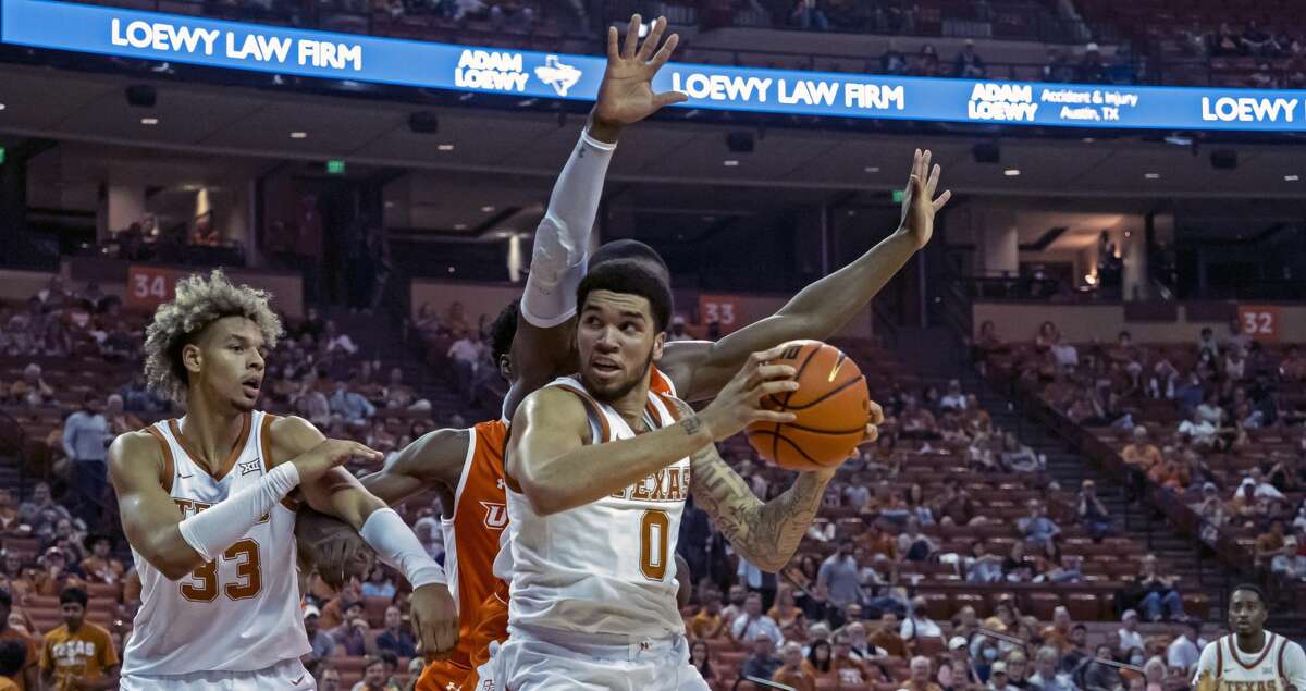 Texas forward Timmy Allen (0) looks to shoot over Texas Rio Grande Valley guard Mike Adewunmi, back, during the first half an NCAA college basketball game, Friday, Dec. 3, 2021, in Austin, Texas. (AP Photo/Michael Thomas)