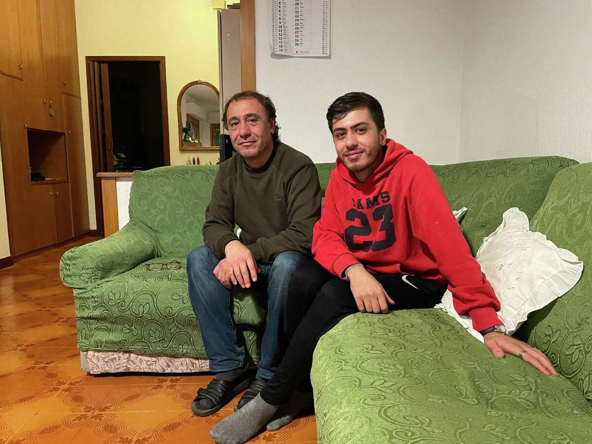 Ahmad Ramy Alshakarji, 56, and one of his sons, Majid, 20, pose at their home in Rome on Dec. 3, 2021.