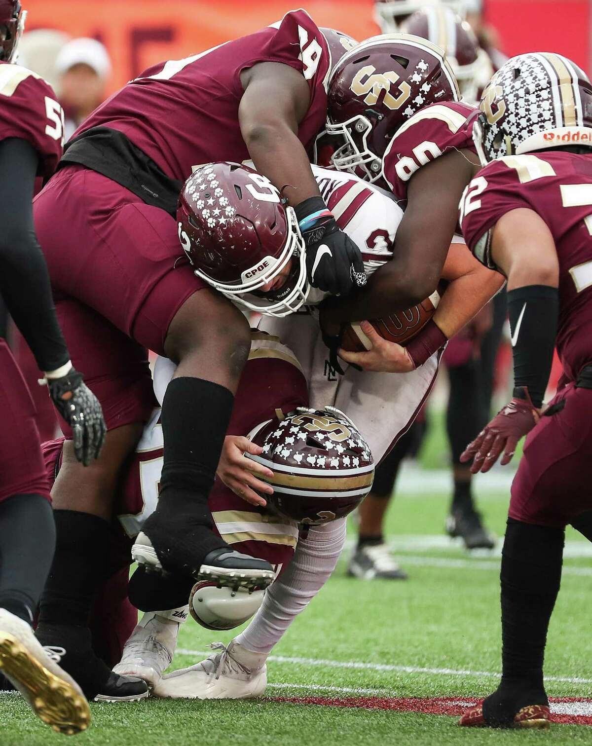 Cinco Ranch Cougars quarterback Gavin Rutherford (12) is sacked by Summer Creek Bulldogs Caden Rain (90) and Amantie Lockhart (99) during the third quarter of a Class 6A Division I regional semifinal high school football game Saturday, Nov. 27, 2021 in Houston.