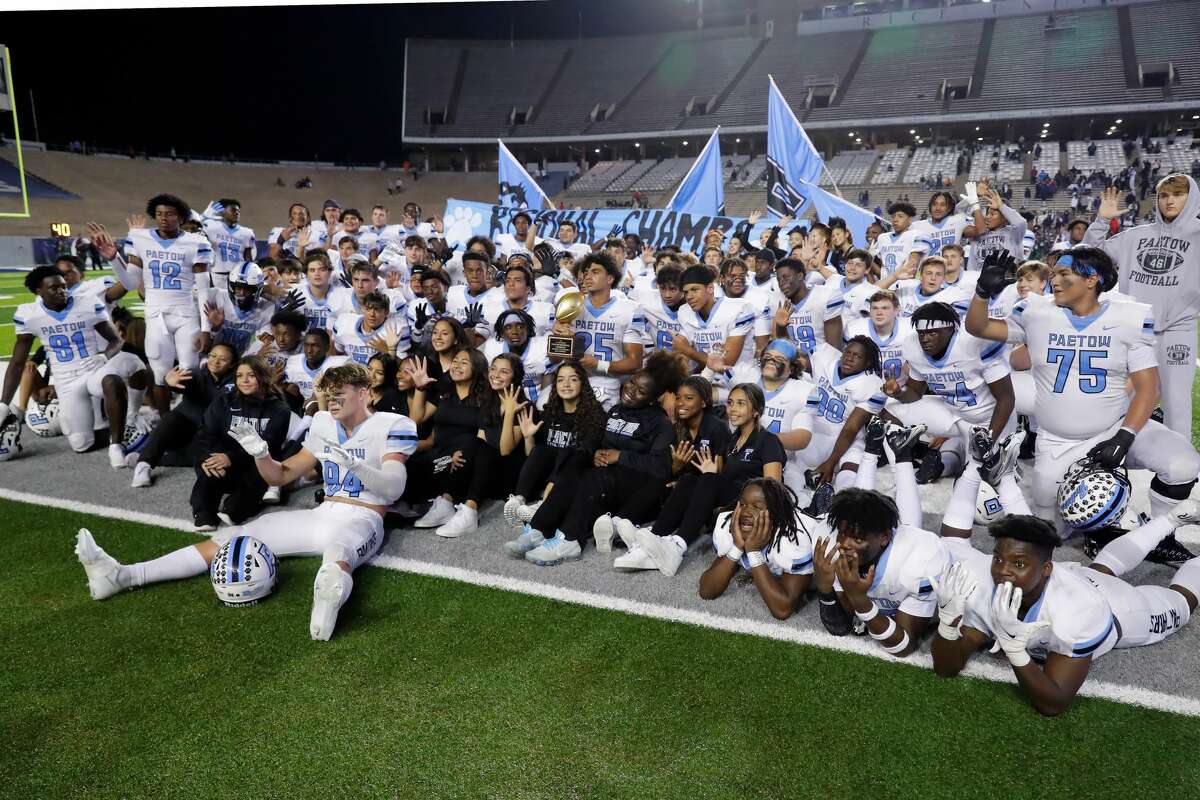 Paetow's Jacob Brown (25), center, holds the Regional trophy as he and his teammates pose for photos after defeating Hightower 35-12 after their Region III-5A Division 1 championship high school football game Friday, Dec. 3, 2021 at Rice Stadium in Houston, TX.