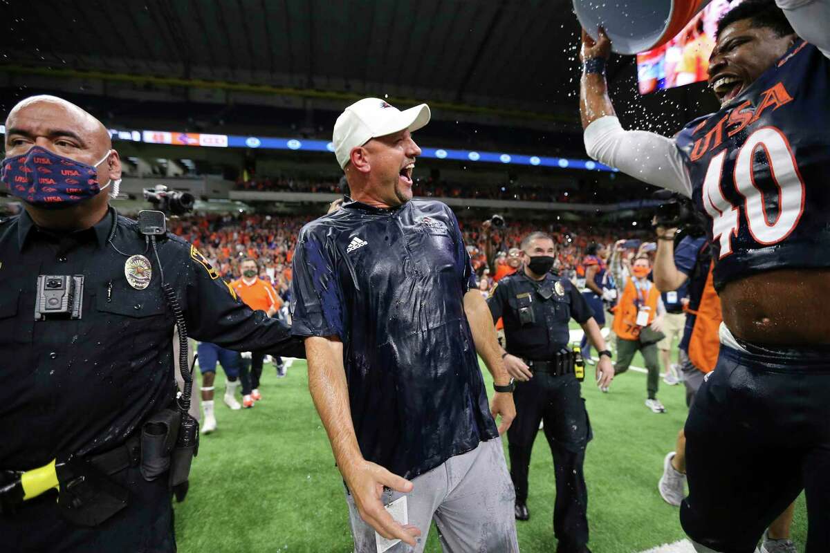 UTSA head coach Jeff Traylor reacts after getting doused with Gatorade from Jimmari Robinson (40) after UTSA defeats Western Kentucky in the 2021 Conference USA Championship football game at the Alamodome on Friday, Dec. 3, 2021. The Roadrunners defeated the Hilltoppers, 49-41, to win the championship.